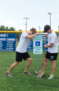 CARSON REEHER | HERALD George Tryfiates, right, and Rob Lewis help to fix handicap parking lot signs during Tigers Serve on Saturday. 