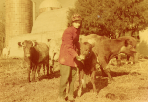 A younger Barbara Gamage proudly stands with one of her pet cows, Babino, on Newstead Farm in Cartersville, where she was raised. 