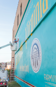 CARSON REEHER | HERALD Joe Giles finishes up the mural Friday evening. 