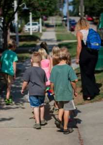 CARSON REEHER | HERALD Kim Hailey, one of the teachers at the Sunrise Learning Center, leads the children to the Grove Street Park for play time.