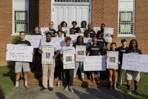 CARSON REEHER | HERALD Peace March participants show off posters remembering African-Americans and police officers whose lives have been lost during recent years.