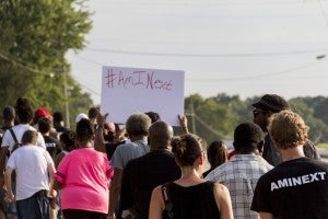 CARSON REEHER | HERALD A participant in the march holds up an #AMINEXT sign.