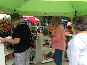 Guests of all ages enjoy the Virginia Children’s Book Festival’s Read Farmville Mobile Book Cart, looking at the books on display at the during the All American Downtown Celebration. 