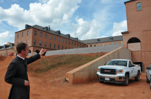 JORDAN MILES | HERALD Father Steven Reuter stands where the church — part of the seminary’s second phase — will be located. He points to a wing of the main seminary building. 