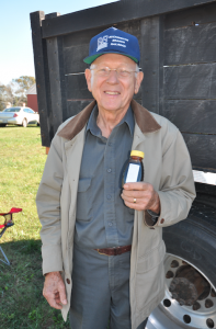 JORDAN MILES | HERALD Robert Bryant, founder and chairman of the board of Buckingham Branch Railroad, smiles as he holds a small vile of molasses, the finished product of the sorghum cook.